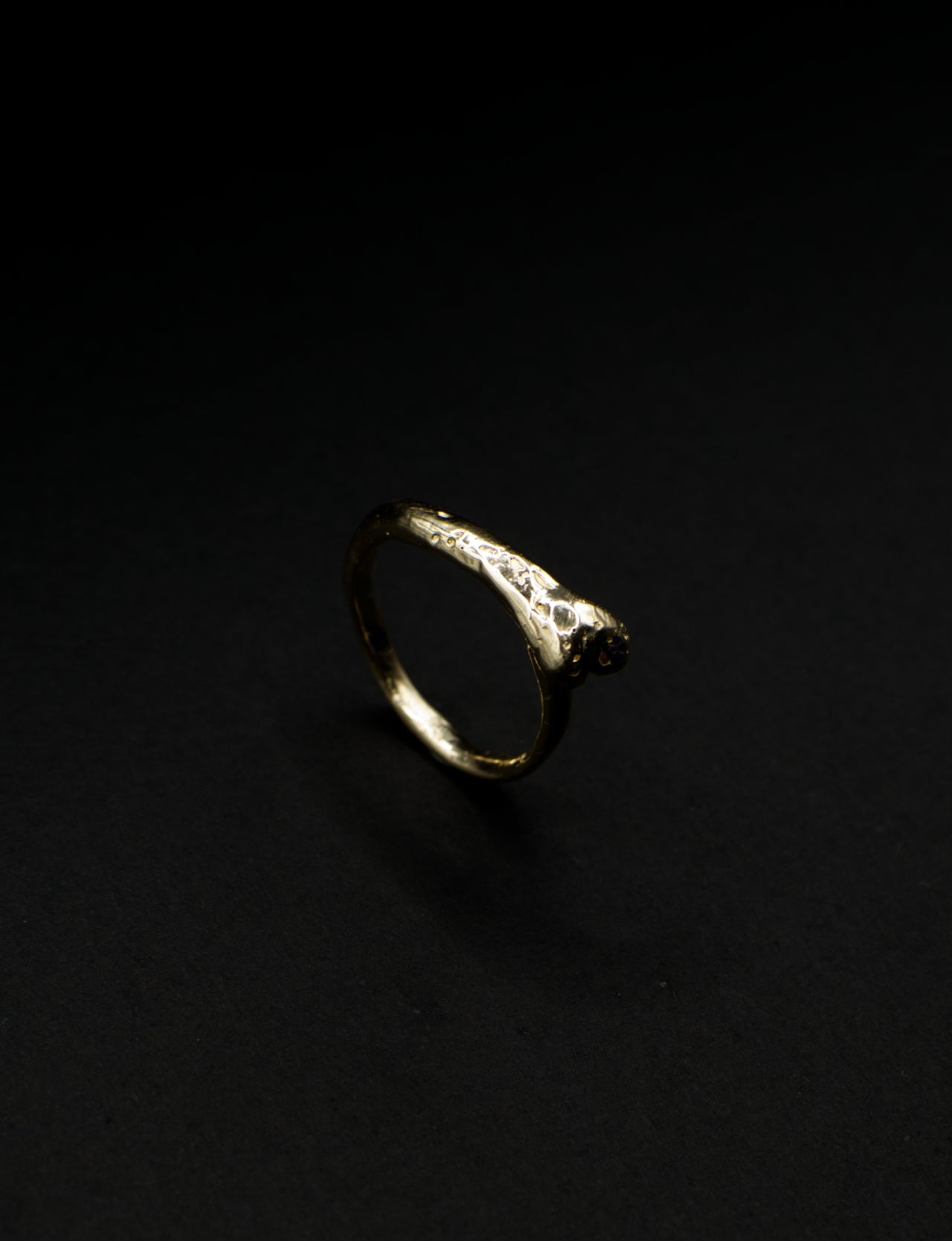 Gold ring with embedded stones on a black background